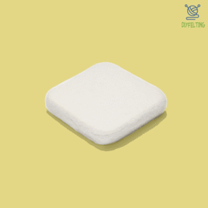 A close-up shot of a hand felting on a pristine white wool felting pad.